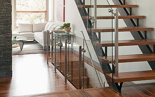 brown wooden stairs with glass baluster